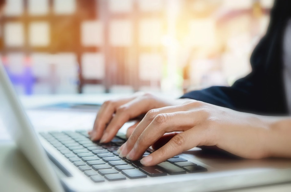 Une secrétaire en charge de la gestion administrative externalisée qui tape sur un clavier d'ordinateur
